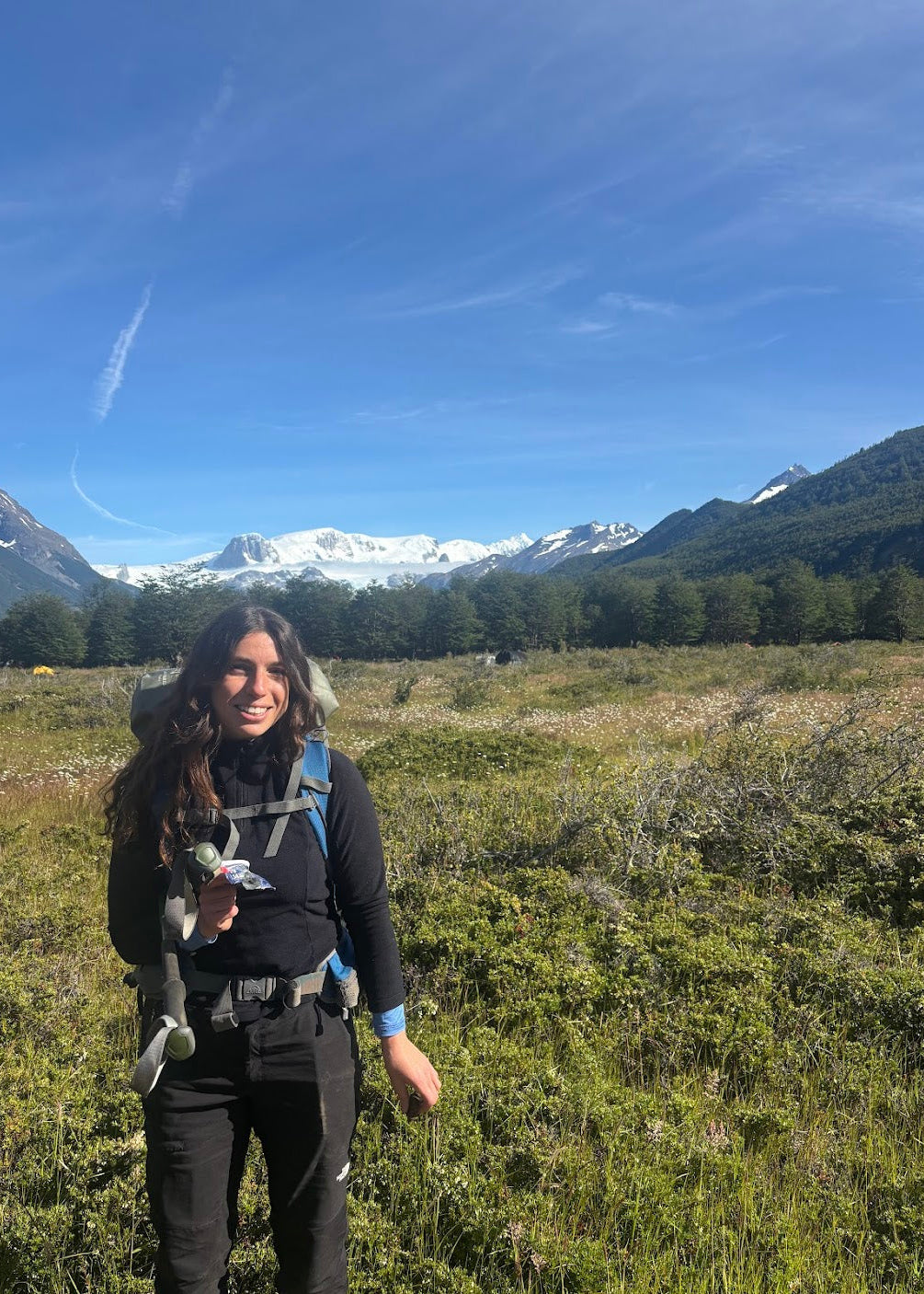 Woman hiking with backpack in mountainous region.